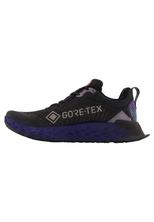 Zapatillas de correr GORE-TEX con parte superior negra y un patrón texturizado, suela púrpura y acentos reflectantes. Diseño ligero para un mejor rendimiento.