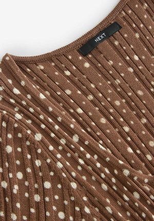 Brown knitted top featuring vertical ribbed texture, cream polka dots, and a black label with "NEXT" at the neckline.