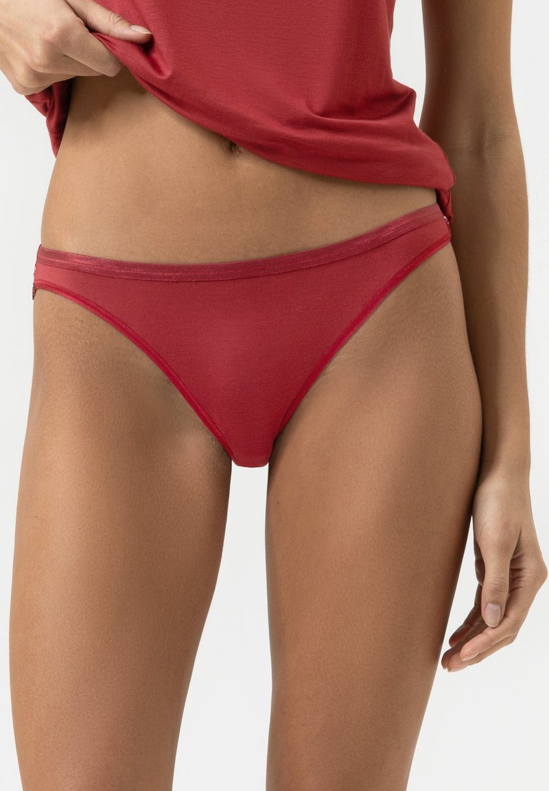 Red cotton bikini underwear with a smooth texture, low-rise design, and slim waistband. The fabric appears stretchy and comfortable.