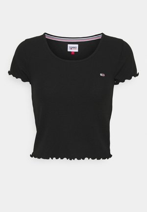 Czarny krótki crop top z zaokrąglonymi brzegami, okrągłym dekoltem i małym logo Tommy Jeans na piersi.