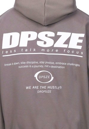 Light gray hoodie with a drawstring, featuring bold white text: "DPSZE less talk more focus" and other motivational phrases.
