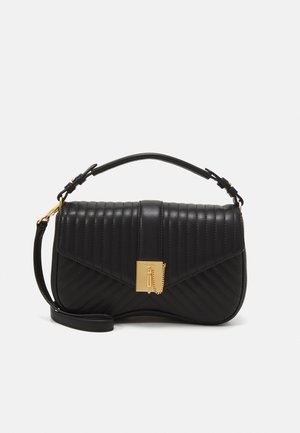 Schwarze gesteppte Lederhandtasche mit goldfarbenem, rechteckigem Verschluss und Kettendetail, Tragegriff oben und verstellbarem Schultergurt vor weißem Hintergrund.