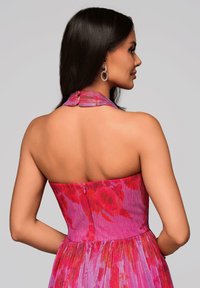 Strapless halterjurk in een levendig roze en rode bloemenpatroon. Gestructureerde stof met een aansluitend lijfje en een vloeiende rok, sluiting aan de achterkant.