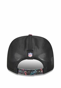 Schwarze Mütze mit strukturiertem Mesh-Design, ausgestattet mit einem mehrfarbigen Spritzmuster am verstellbaren Band und einem NFL-Logo-Tag.