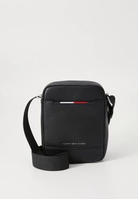 Sort læder skuldertaske med rektangulær form, der har en struktureret overflade, justerbar rem og et tricolor accenter på forsiden.