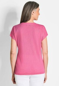 Roze T-shirt met korte mouwen, in een relaxte pasvorm en een ronde halslijn, gemaakt van zacht materiaal, met een effen textuur en zonder patronen.