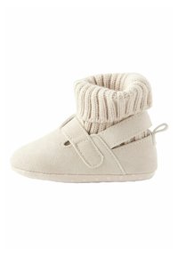 Beežist kampsu konj, millel on kudumisega äär, Velcro-kinnitus ja kummist tallad, millel on tekstuuriga täpid haardeks. Pehme ja paindlik disain mugavuseks.