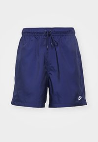 Marinblå herrbadshorts med elastisk midja, snörning fram och liten vit Nike-logga på vänster ben.
