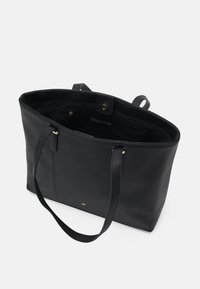 Sac fourre-tout en cuir noir avec deux longues poignées, une poche zippée intérieure et une fermeture à pression. Texture lisse et design minimaliste.