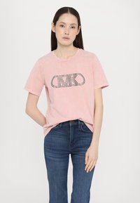 Rosa bomull t-skjorte med rund hals og korte ermer. Har et svart logo dekorert med rhinestones på forsiden.