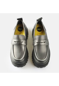 Black chunky loafers made of glossy leather with a rounded toe, elastic side panels, and yellow insoles. Features a back pull tab for ease of wear.