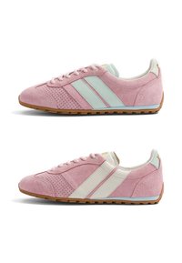 Paire de baskets en daim rose avec côtés perforés, rayures bleu clair et blanches, lacets blancs et semelles en caoutchouc marron, montrée de profil latéral.