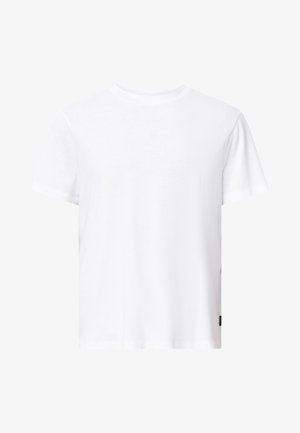 Biała bawełniana koszulka z okrągłym dekoltem, krótkimi rękawami, luźnym krojem oraz małą naszywką z logo na dolnej stronie. Bez wzorów ani grafik.