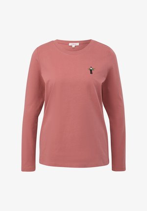 Donsrose vrouwen T-shirt met lange mouwen, ronde hals en een kleine geborduurde figuur die zwarte broek en een groene jas draagt op de linkerborst.