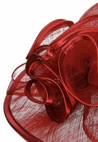 Rote Netzmütze mit geschlungenen Bändern und geschichteten Blumenelementen, mit breiter Krempe und strukturiertem Oberflächen.