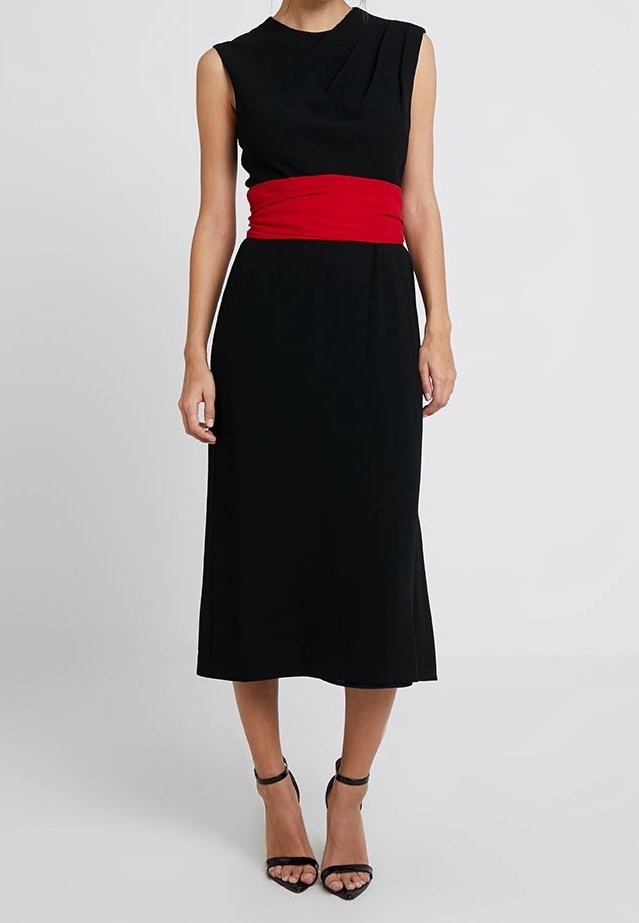 Robe midi noire sans manches avec une large ceinture rouge haute, portée avec des sandales noires à talons hauts avec bride à la cheville.