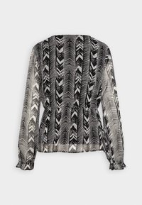 Blusa trasparente bianca e nera con motivo a zigzag. Maniche lunghe con polsini arricciati, vita aderente e scollatura rotonda.