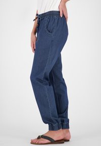 Donkerblauwe denim joggingsbroek met een elastische tailleband met trekkoord, zijzakken en elastische boorden bij de enkels.