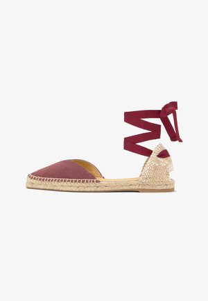 Flat espadrille shoe with maroon fabric front, woven natural fiber sole, and maroon ankle wrap ribbon against white background.