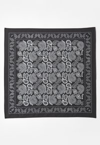 Sort bandana med hvide paisley-mønstre og teksten "Nørgaard", med en dekorativ kant. Fremstillet af blødt stof med en glat tekstur.