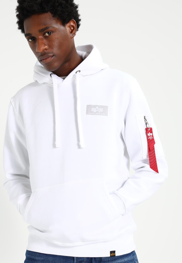 Witte hoodie met een ritszak op de mouw, voorzien van een logo patch en een koordcapuchon. Getextureerde stof, eenvoudig ontwerp en een losse pasvorm.