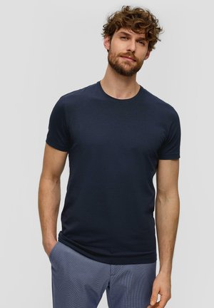T-shirt bleu marine à manches courtes en coton, avec un col rond et une coupe ajustée, associé à un pantalon à motifs.
