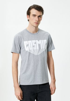 Camiseta de algodón gris con mangas cortas, que presenta un gran diseño gráfico en blanco con la palabra "COSMIC" en el pecho y un cuello redondo clásico.