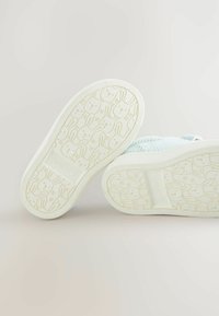 Baskets texturées bleu clair avec une semelle blanche, ornées d'un motif de lapins répété. Le design présente un talon plat et un bout arrondi.