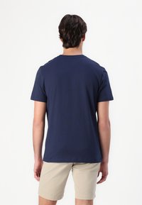 Camiseta de manga corta color azul marino con cuello redondo, fabricada en suave material de algodón y con un diseño sencillo. El corte es holgado y adecuado para un uso casual.