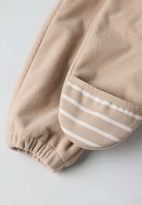 Beige fleece stof met een manchet met horizontale strepen in een lichtere tint, elastische afwerking bij de pols, zachte textuur.