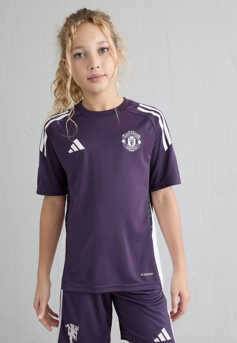 Lila Manchester United Sporttrikot mit weißen Akzenten, kurzen Ärmeln und Logo auf der Brust; kombiniert mit passenden lilafarbigen Shorts.