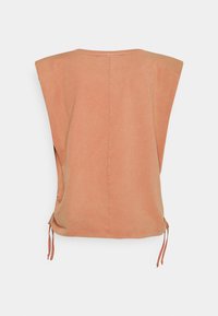 Top de algodão com costas drapeadas em terracota suave, apresentando um design de ombro largo, laços laterais para ajuste e textura suave.