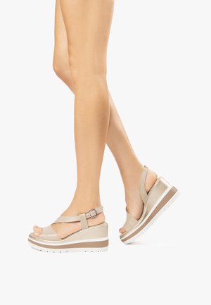 Sandali wedge beige con design open toe, cinturino regolabile, materiale testurizzato e accenti di sole bianchi e marroni.