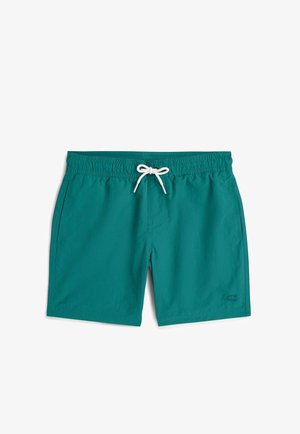 Shorts de bain bleu sarcelle avec ceinture élastique, cordon blanc, poches latérales et petit logo sur la jambe droite en bas.