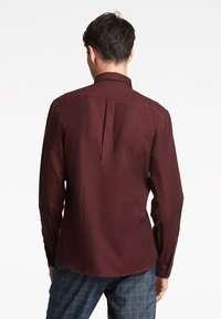Bordeaux zacht langemouw overhemd in een gestructureerde stof, met een klassieke kraag en een verticale naaddetail aan de achterkant.