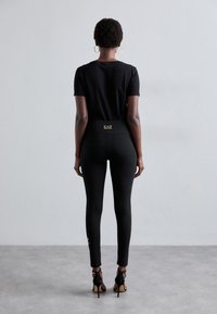 EA7 Emporio Armani Κολάν - Παντελόνια - black/gold-coloured