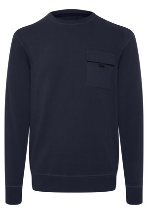 Tumesinise kananäo kampsun, mis on valmistatud puuvillast, omab ümmargust kaela, pikkade varrukatega ning rinna taskut, millel on klapp ja sildiga detail.