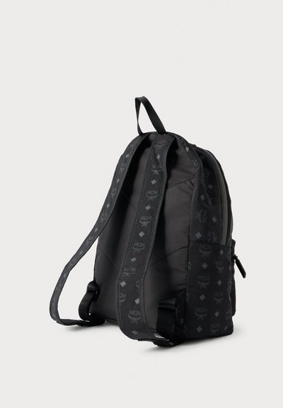 Mochila preta acolchoada com formato estruturado, apresentando padrões discretos de logotipo e alças ajustáveis. Bolso lateral com fecho de correr.