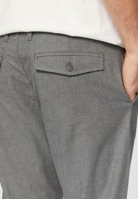 Grijze herringbone broek met een rechte pasvorm, voorzien van een dubbele knopenzak en zijzakken voor functionaliteit.