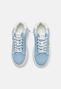 Sneaker in denim azzurro chiaro con suole in gomma bianca, dotate di occhielli in argento, lacci bianchi e una punta testurizzata con un accento decorativo.