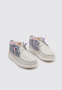 Botas de tobillo de lona con acentos de patrón multicolor, material principal gris claro, suelas de goma blancas y detalles de cordones en contraste.