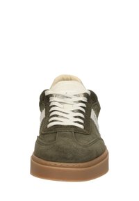 Semišové tenisky v olivově zelené barvě s bílým jazykem a šňůrkami. Mají kulatou špičku a hnědou gumovou podrážku. Boční ozdoby jsou bílé.