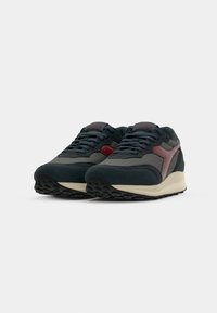 Men's sneakers in navy mesh and suede with red accents, featuring a sturdy rubber sole and a classic low-top design.