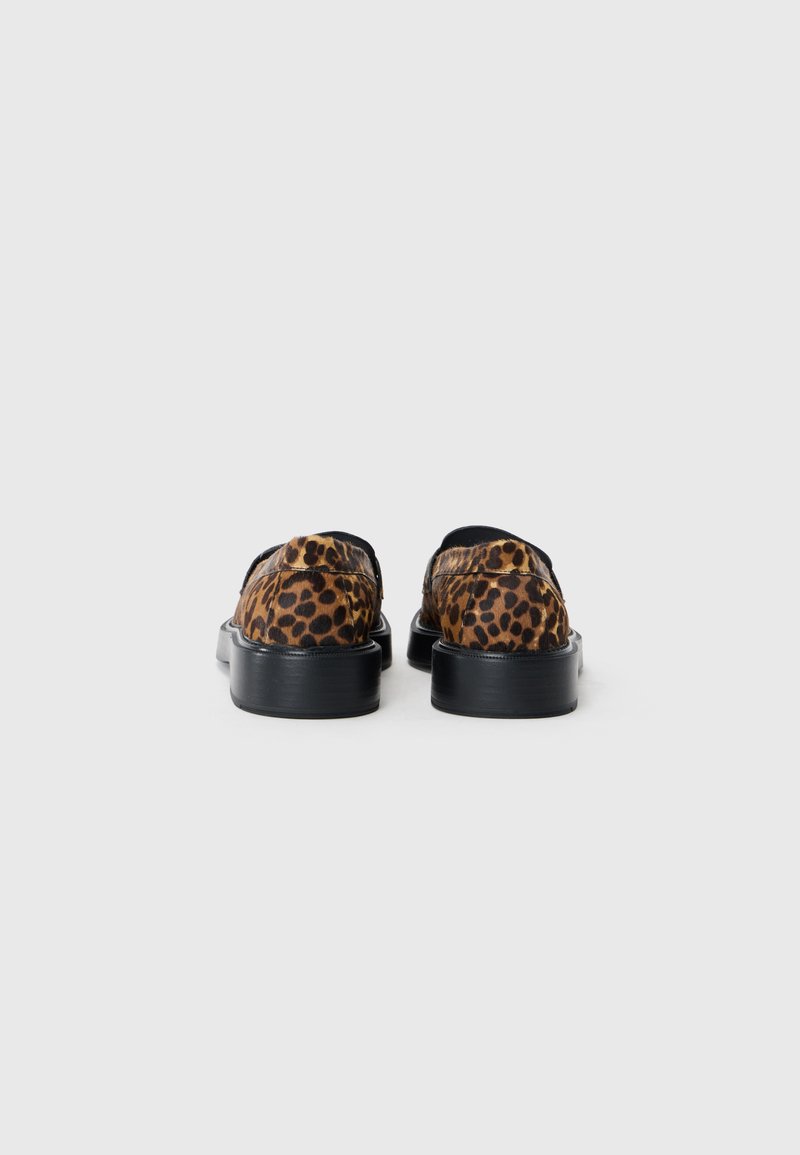 Scarpe slip-on con stampa leopardata, suola in gomma nera e punta arrotondata. Texture liscia con cuciture visibili e design a profilo basso.