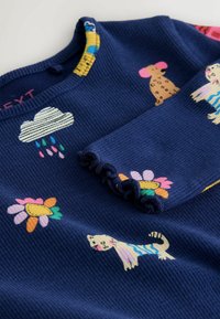 Námořnický žebrovaný top s dlouhým rukávem s barevnými aplikacemi zvířat a květin, s kulatým výstřihem a volánovými manžetami rukávů.