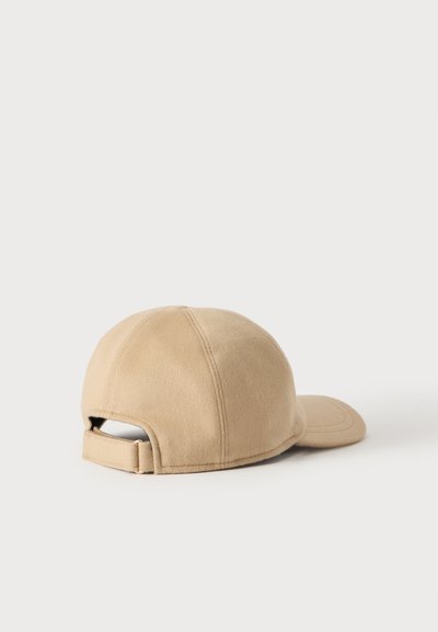 Casquette de baseball beige vue de dos avec une sangle réglable et une visière incurvée sur un fond clair uni.