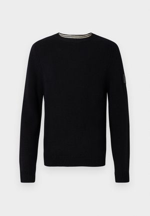 Sort sweater med rund halsudskæring, ribstrikkede manchetter og kant. Vævet struktur og en kontrasterende syning ved halsudskæringen tilføjer en diskret interesse.
