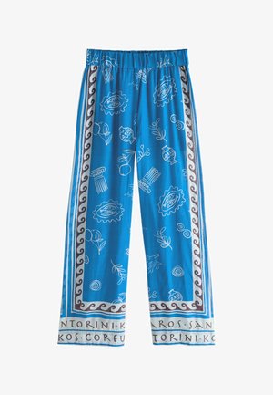 Blue wide-leg pants with white Greek-inspired patterns, brown wave border, and city names printed along the hem.