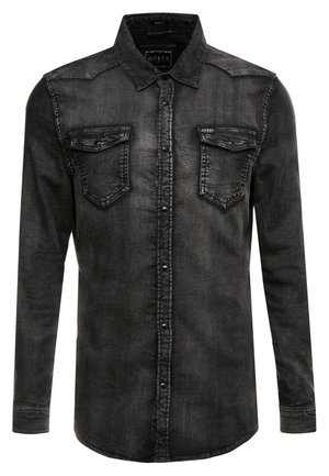 Chemise en denim noir à manches longues avec fermeture par boutons, deux poches poitrine à rabat et un col, affichant une texture légèrement délavée.
