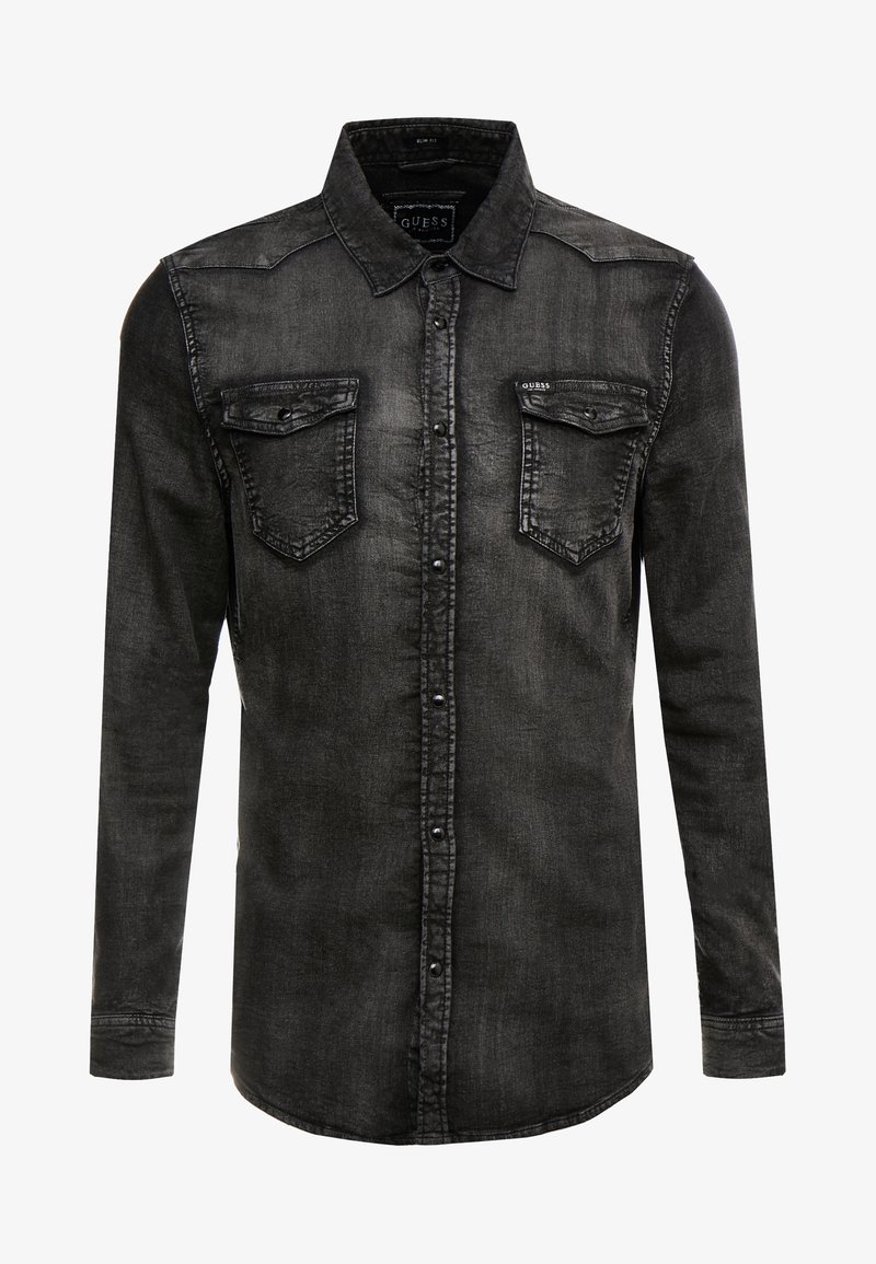 Chemise en denim noir à manches longues avec fermeture par boutons, deux poches poitrine à rabat et un col, affichant une texture légèrement délavée.